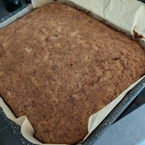 Birnenkuchen ohne Zucker frisch aus dem Ofen in einer eckigen Backform mit Backpapier, die Oberfläche goldbraun