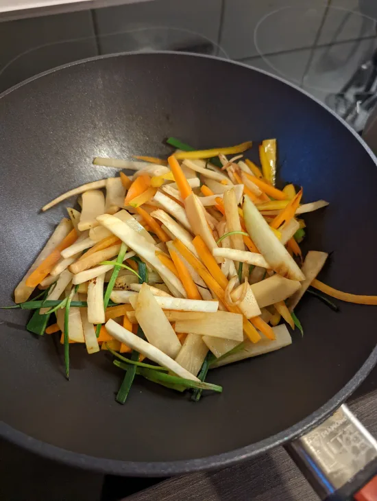 Das Gemüse brät im Wok an und bekommt erste Röstspuren